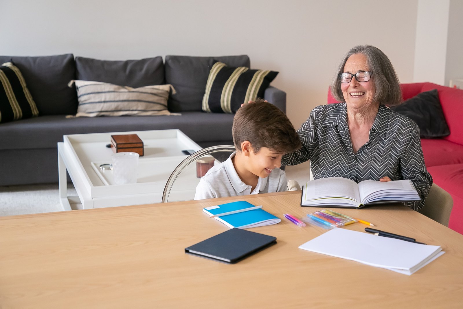 An older woman and a child looking at a book together