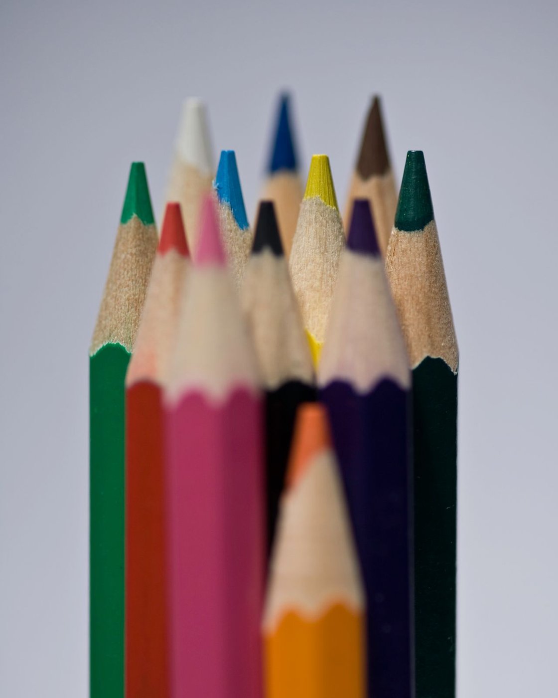 A close view of the sharpened tips of a group of colored pencils.