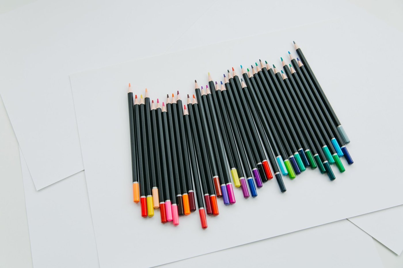 Colored pencils arranged on white paper